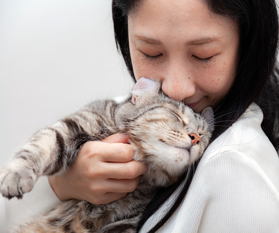 How to bond with your cat - Woman cuddling and bonding with cat