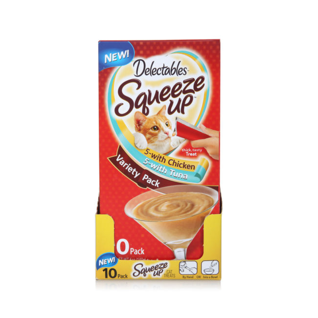 Delectables SqueezUp Variety Pack is the first gourmet wet cat treat where feeding is interactive. Front of opened carton picturing a cat eating from a squeezeup tube being held by a hand.