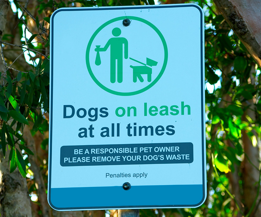 Dog Park Etiquette - Sign that reads dogs on leash at all times. Be a responsible pet owner. Please remove your dog's waste. Penalties apply. Penalties apply.