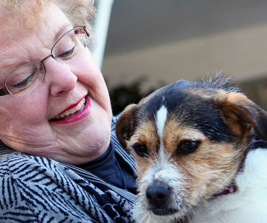Elderly woman holding small pet dog