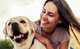 Young woman with dog labrador retriever.