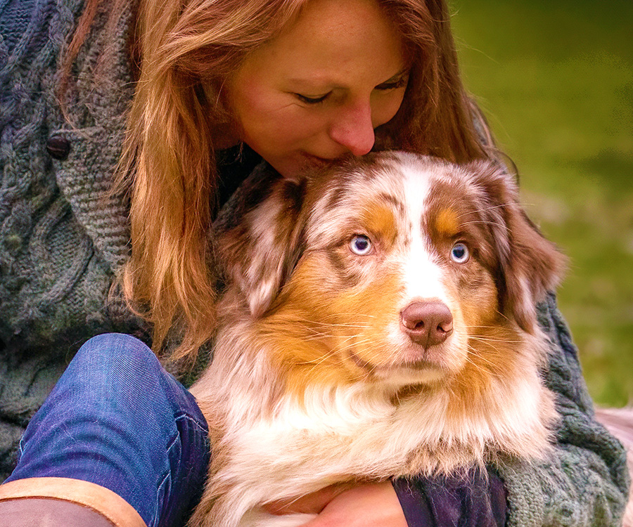 What can i give my dog to calm him down from fireworks? - Woman kisses Australian Shepherd dog lovingly