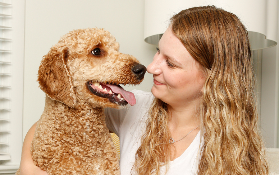 Woman hugging dog washed with Hartz True Coat dog detangler shampoo